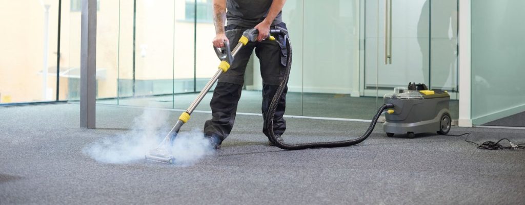 Image d'un aspirateur sur moquette, illustrant le processus de nettoyage en profondeur pour un entretien efficace des surfaces textiles